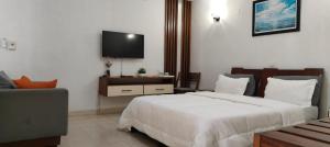 ein Schlafzimmer mit Bett und Flachbildfernseher in der Unterkunft Hotel Atlantic View in Muanda