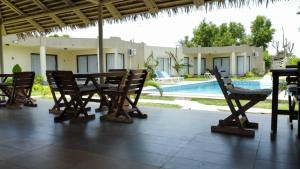 eine Terrasse mit Tisch und Stühlen und ein Pool in der Unterkunft Hotel Atlantic View in Muanda
