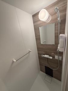 a bathroom with a shower and a mirror at HOTELanoh in Saga