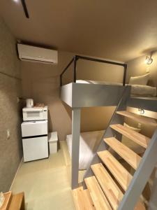 a small room with a bunk bed and a staircase at HOTELanoh in Saga