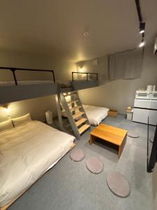 a room with two bunk beds and a table at HOTELanoh in Saga
