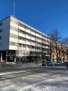 a large building with cars parked in front of it at Iso kuutti in Savonlinna
