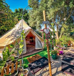 a tent with a street sign in a garden at Bell Tent Lovers by Casa das Artes in Luz de Tavira
