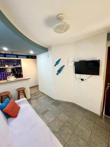 a bedroom with a bed and a flat screen tv at Flat em natal beira mar in Natal +34 photos