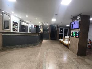 a lobby with a bar and a tv in a building at Stratus Vila Hotel in Volta Redonda
