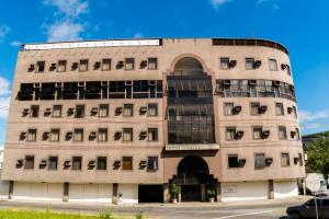 a large tan building with a large window at Stratus Vila Hotel in Volta Redonda