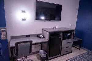 a room with a desk with a phone and a microwave at Budget Inn in Alamogordo