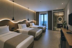 a hotel room with two beds and a television at Hotel Duamare LIVADHI in Himare