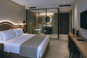 a bedroom with a large bed and a bathroom at Hotel Duamare LIVADHI in Himare
