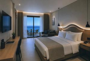 a hotel room with a large bed and a living room at Hotel Duamare LIVADHI in Himare