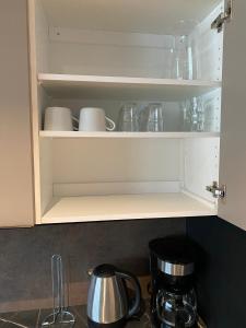 a kitchen cabinet with cups and dishes in it at Olavi C in Savonlinna +12 photos