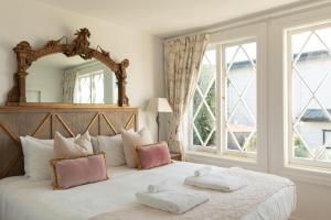 a bedroom with a large bed with two towels on it at The Vintage Cottage in Oneroa