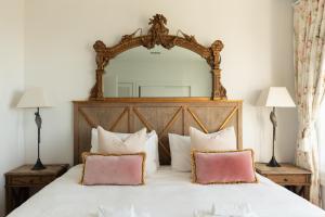 a bedroom with a large mirror above a bed at The Vintage Cottage in Oneroa