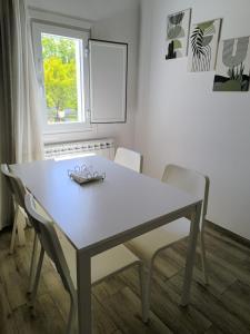 a white table with two chairs and a window at Casa Fontenlos in Tui