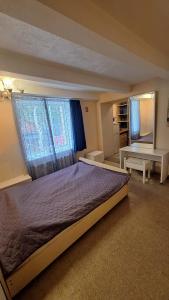 a bedroom with a large bed and two windows at Apartment SKAISTUMS in Jūrmala +114 photos