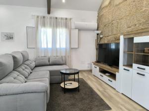 a living room with a couch and a television at Casa Fontenlos in Tui