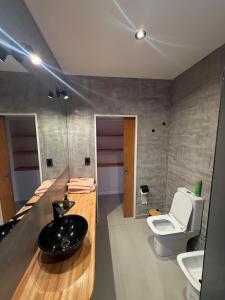 a bathroom with a black sink and a toilet at La Rosadita in Concordia +9 photos