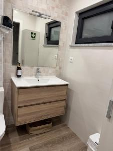 ein Badezimmer mit Waschbecken und Spiegel in der Unterkunft Malecón Do Azeite in Moura + 10 Fotos