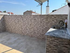 eine Küche mit Spüle und einer Ziegelwand in der Unterkunft Malecón Do Azeite in Moura