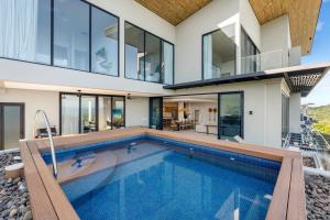 a house with a swimming pool in front of it at Oceanview Penthouse - Private Pool - Reserva Conchal in Playa Conchal