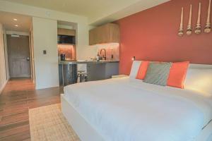 a bedroom with a large white bed and a kitchen at Casa México in Mexico City