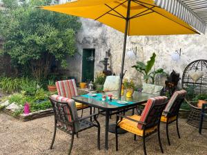 a table with a yellow umbrella and chairs at Serendipity Eymet B&B in Eymet