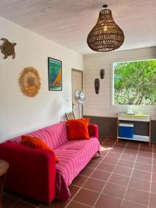 a living room with a red couch and a window at Villa Piscine - Maracudja in Les Anses-dʼArlets
