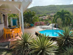 a patio with a table and chairs and a swimming pool at Villa Piscine - Maracudja in Les Anses-dʼArlets