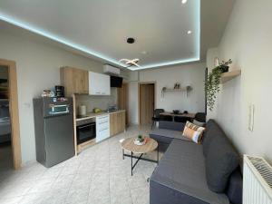 a living room with a blue couch and a kitchen at La casa de verano in Skala Sotiros