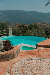 a swimming pool with a turquoise water at Cortijo Privilegio in Lanjarón