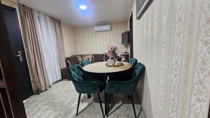 a room with a table with green chairs and a couch at ČANJ Apartman Slavica in Čanj