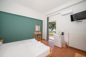 a bedroom with a large white bed and a television at Naya in Kissamos