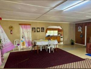 a living room with a table and a kitchen at JayDees Homestay in Taveuni