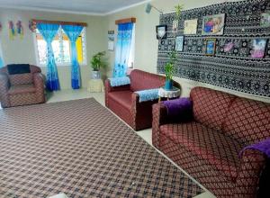 a living room with red furniture and blue curtains at JayDees Homestay in Taveuni