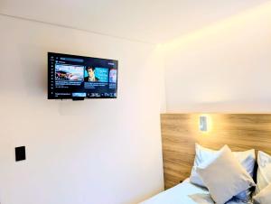 a bedroom with a bed with a television on the wall at Iwana stay in Bogotá