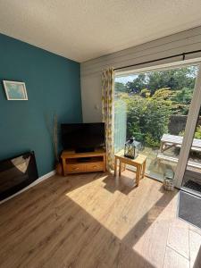 a living room with a television and a large window at 78 Atlantic Reach in Newquay