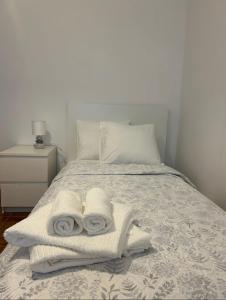 a white bed with towels on top of it at Casa do Evaristo in Nabais
