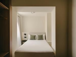 a bed with two pillows in a small room at Sercotel Toledo Imperial in Toledo +28 photos