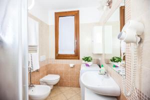 a bathroom with a sink and a toilet and a mirror at Agriturismo Ca' Baccan in Cavallino-Treporti