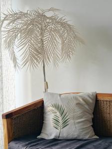 a palm tree above a couch with a pillow at Amandine - Vue mer Pointe-à-Pitre in Pointe-à-Pitre