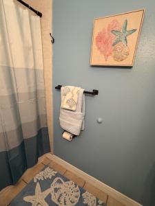a bathroom with a shower curtain and a towel at The Corner Cottage in Palm Harbor +19 photos