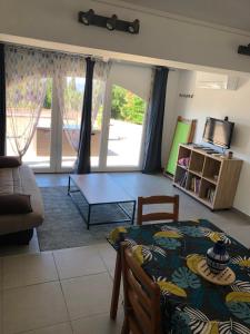 a living room with a table and a couch at Gîte Apaisant in Llauro +4 photos
