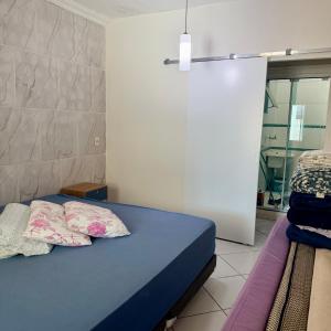 a bedroom with a blue bed with two pillows at Casa de 2 QUARTOS COM PISCINA in Balneário Camboriú +26 photos