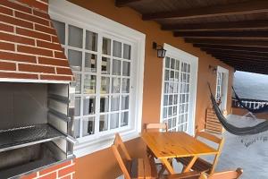 a porch with a table and chairs and a hammock at Chalé Private c/ Vista e garagem in Ilhabela