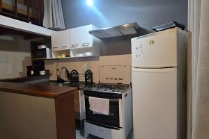 a kitchen with a stove and a refrigerator at Chalé Private c/ Vista e garagem in Ilhabela