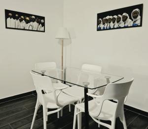 a glass table and white chairs in a room at Amandine - Vue mer Pointe-à-Pitre in Pointe-à-Pitre +12 photos