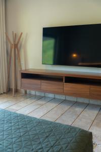 a flat screen tv sitting on top of a wooden entertainment center at Nicer Huatulco Condo in Tangolunda