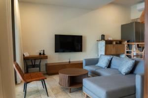 a living room with a blue couch and a tv at Nicer Huatulco Condo in Tangolunda