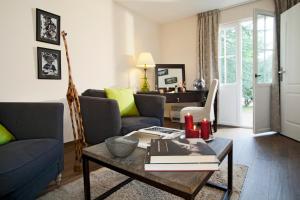 sala de estar con mesa de centro y libros en Domaine de Bellevue, The Originals Relais, en Neufmoutiers-en-Brie