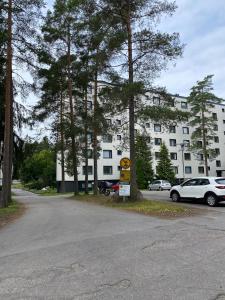 ein Parkplatz vor einem großen weißen Gebäude in der Unterkunft Mon Koti in Turku